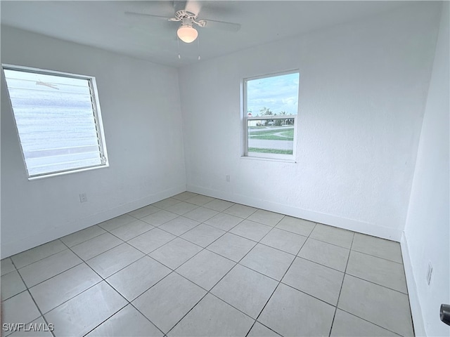 spare room featuring light tile patterned floors and ceiling fan