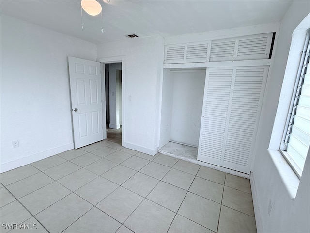 unfurnished bedroom with light tile patterned floors and a closet