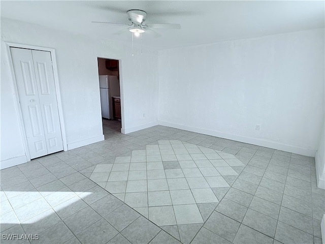 tiled spare room with ceiling fan