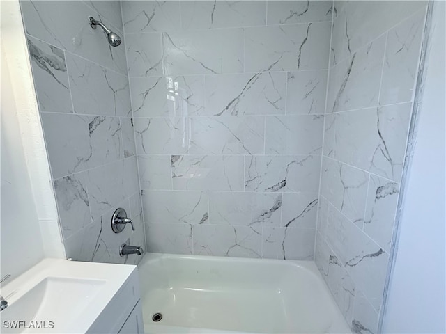 bathroom featuring tiled shower / bath combo and vanity