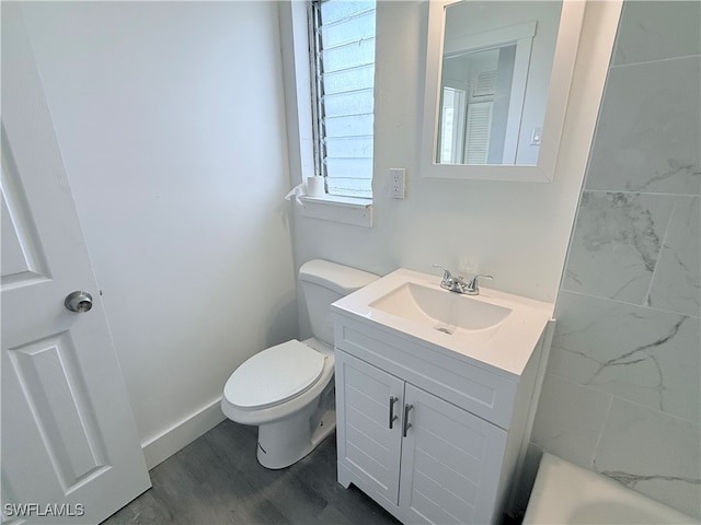 bathroom featuring toilet, vanity, and hardwood / wood-style floors