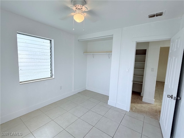 unfurnished bedroom featuring light tile patterned floors, ceiling fan, and a closet