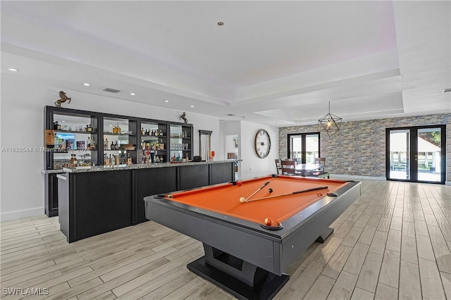 recreation room with french doors, a tray ceiling, billiards, and light wood-type flooring