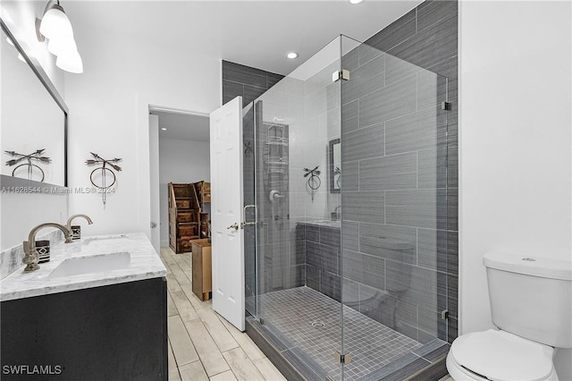 bathroom featuring vanity, walk in shower, and toilet