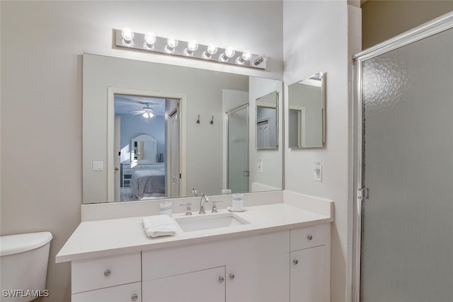 bathroom featuring vanity, ceiling fan, toilet, and walk in shower