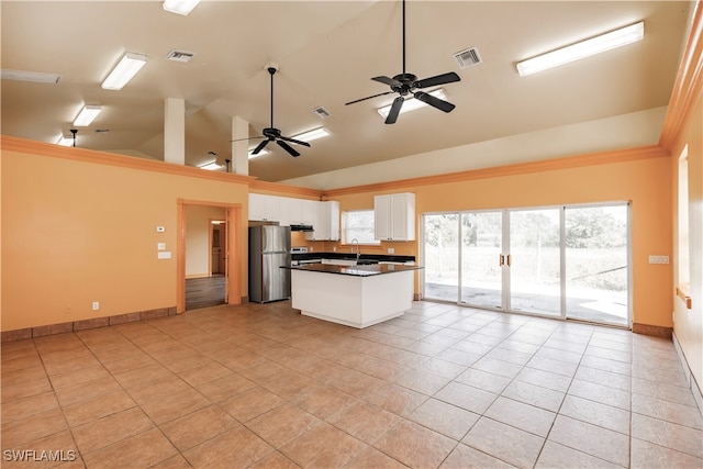 kitchen with white cabinetry, ceiling fan, stainless steel fridge, vaulted ceiling, and light tile patterned floors