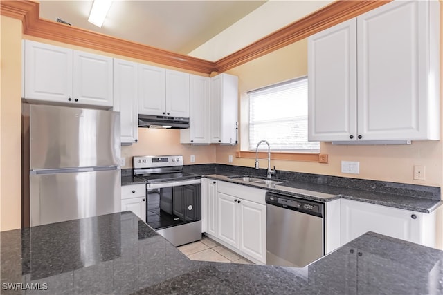 kitchen with white cabinets, appliances with stainless steel finishes, dark stone countertops, and sink