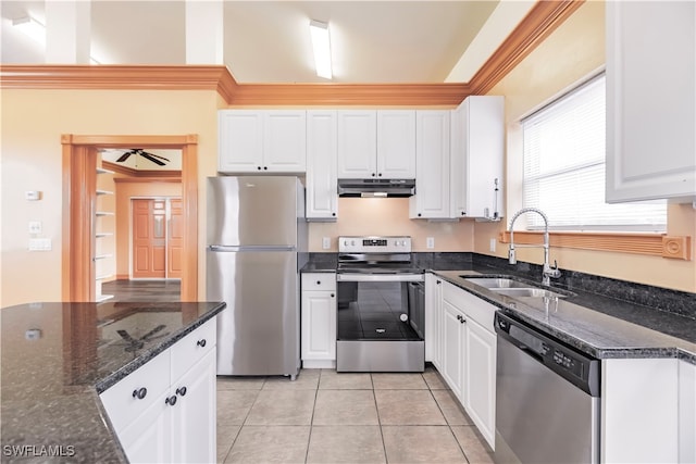 kitchen featuring white cabinets, sink, dark stone countertops, appliances with stainless steel finishes, and light tile patterned flooring