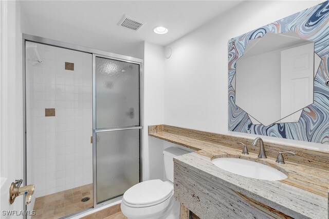 bathroom featuring toilet, walk in shower, and vanity