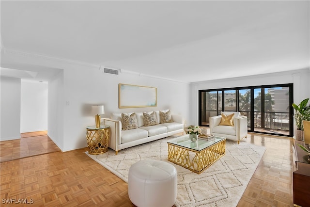 living room featuring ornamental molding and light parquet flooring