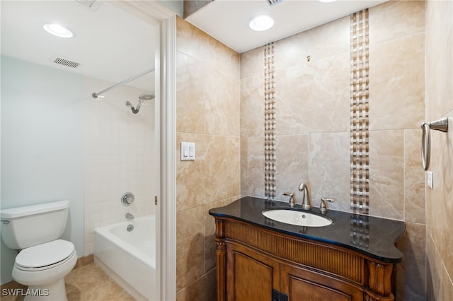 full bathroom with toilet, tile walls, tile patterned floors, tiled shower / bath, and vanity