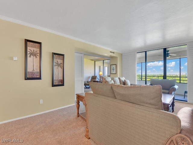 carpeted living room with ornamental molding and ceiling fan