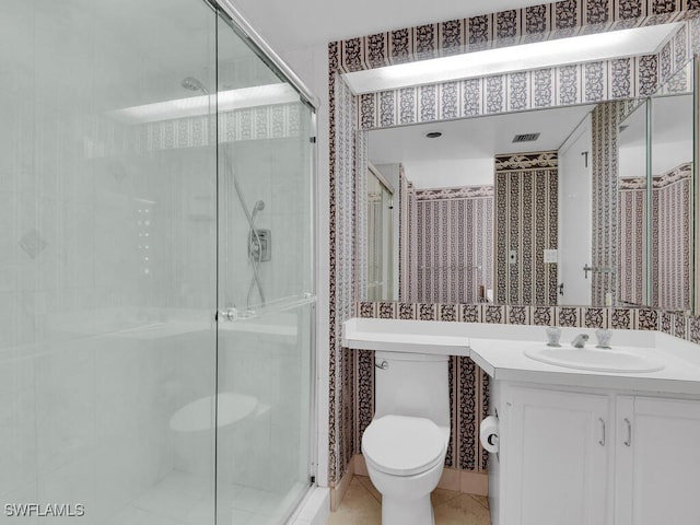 bathroom featuring vanity, toilet, and a shower with door