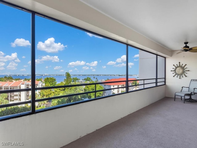 unfurnished sunroom with a water view and ceiling fan