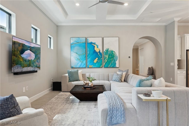 tiled living room with ceiling fan and crown molding