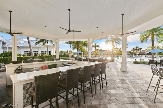 view of patio featuring an outdoor bar and ceiling fan