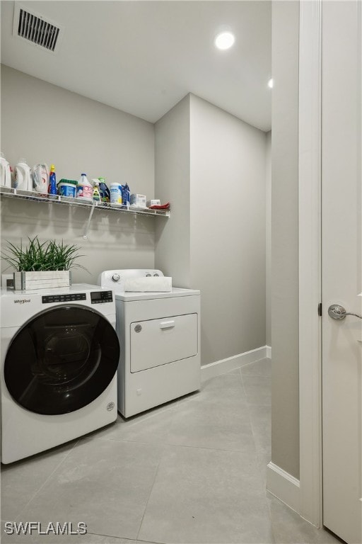 laundry room featuring light tile patterned flooring and washing machine and clothes dryer