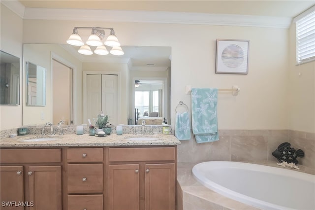 bathroom with ornamental molding, a relaxing tiled tub, and vanity