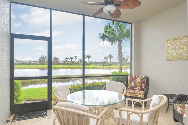 sunroom featuring a water view, a healthy amount of sunlight, and ceiling fan