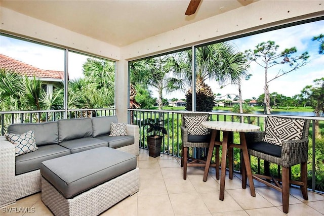 sunroom / solarium featuring a water view and ceiling fan