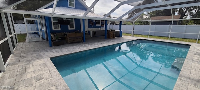 view of swimming pool featuring a lanai, outdoor lounge area, ceiling fan, and a patio area