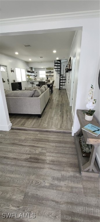 unfurnished living room featuring hardwood / wood-style floors and ornamental molding