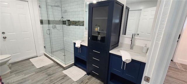 bathroom featuring walk in shower, hardwood / wood-style floors, and vanity