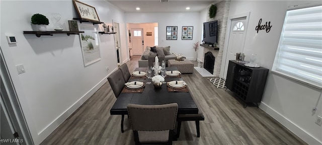 dining room featuring a large fireplace and dark hardwood / wood-style flooring