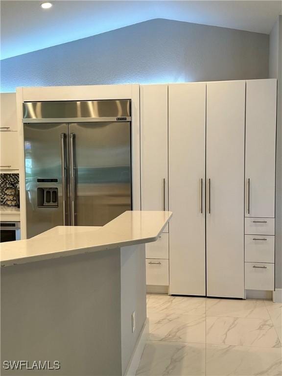 kitchen with tasteful backsplash, appliances with stainless steel finishes, and white cabinetry