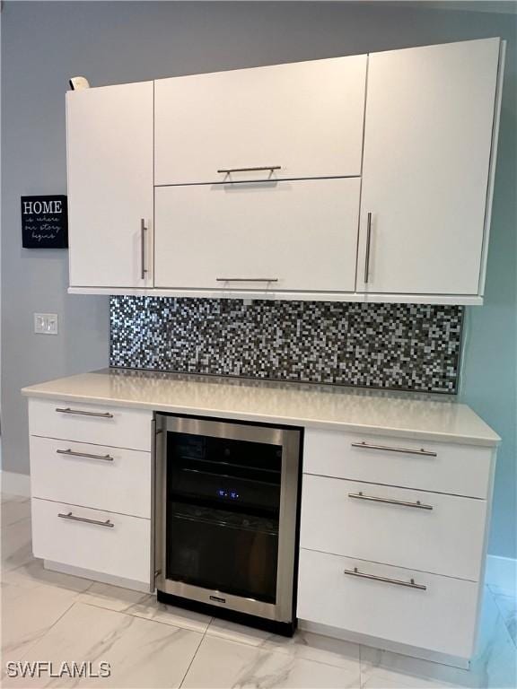 kitchen featuring decorative backsplash, white cabinetry, and wine cooler