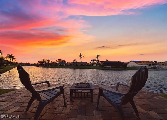 dock area with a water view, a fire pit, and a patio