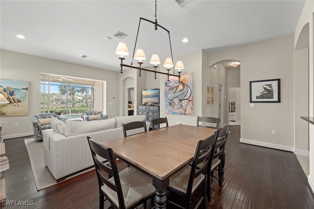 dining room with an inviting chandelier and dark hardwood / wood-style floors