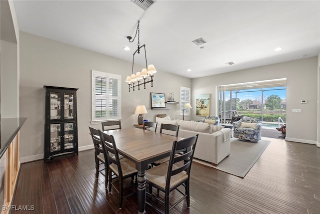 dining space with an inviting chandelier, dark hardwood / wood-style flooring, and a healthy amount of sunlight