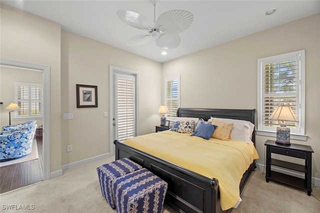 carpeted bedroom featuring multiple windows and ceiling fan