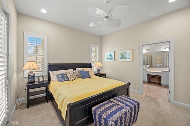 bedroom with light carpet, ensuite bathroom, and ceiling fan