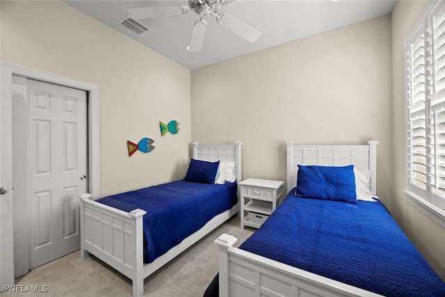 carpeted bedroom featuring multiple windows, ceiling fan, and a closet