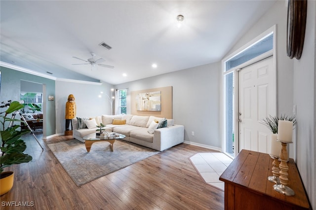 living room with ceiling fan, light hardwood / wood-style floors, and lofted ceiling