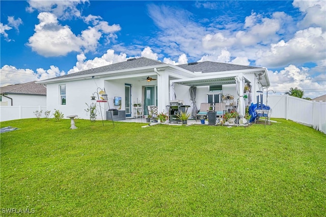 rear view of house with a yard, ceiling fan, and a patio area