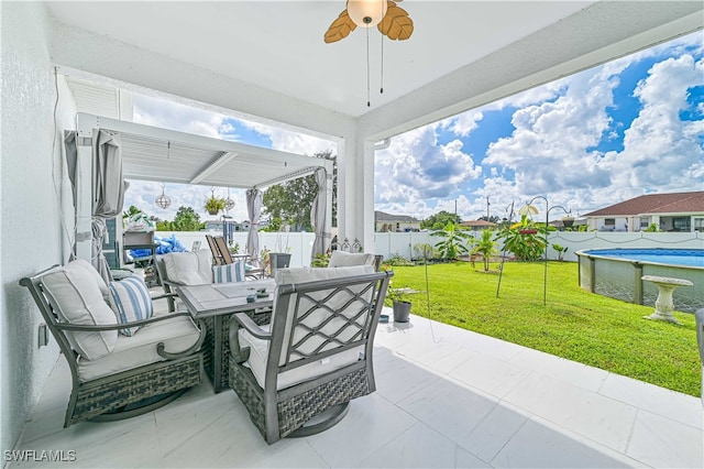 view of patio / terrace featuring ceiling fan and a fenced in pool