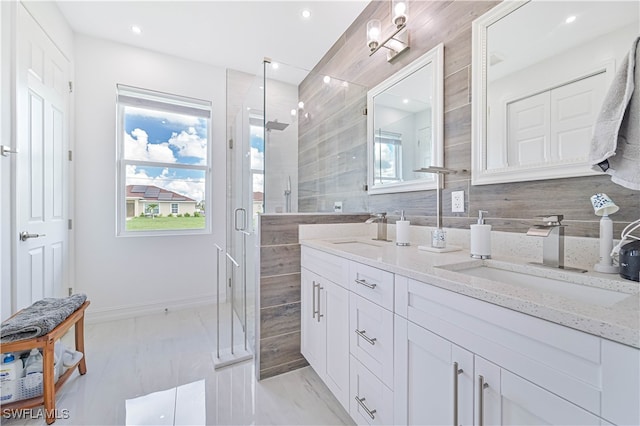 bathroom with backsplash, vanity, and a shower with shower door