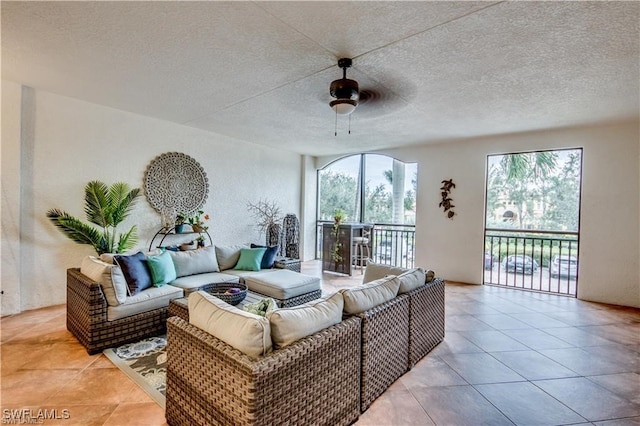 tiled living room featuring ceiling fan and a textured ceiling