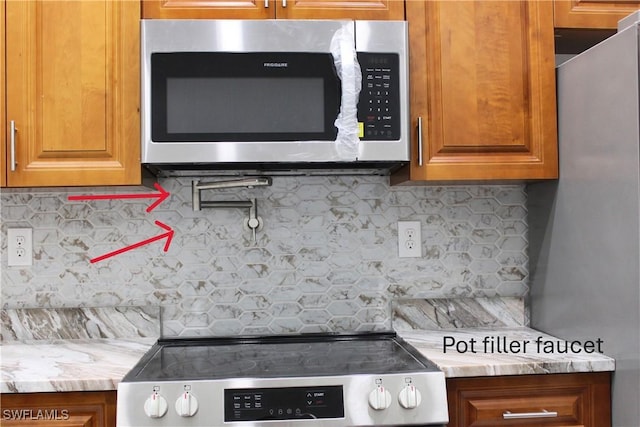 interior space with stainless steel appliances and decorative backsplash