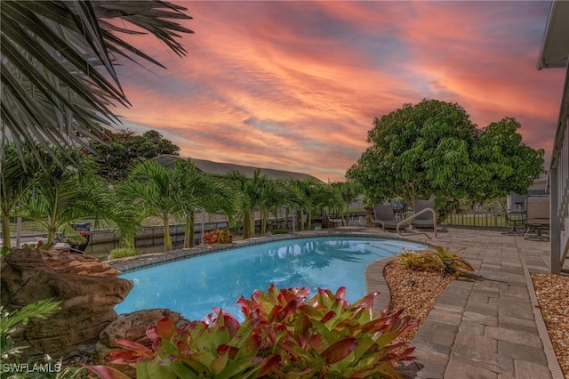 pool at dusk with a patio