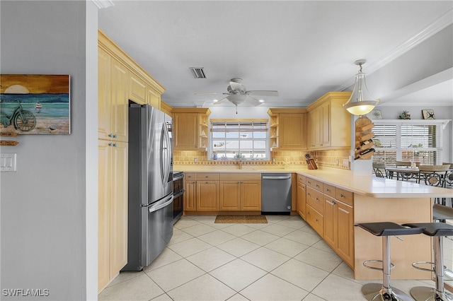 kitchen with backsplash, appliances with stainless steel finishes, kitchen peninsula, and a healthy amount of sunlight