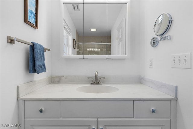 bathroom with vanity and a shower with shower door