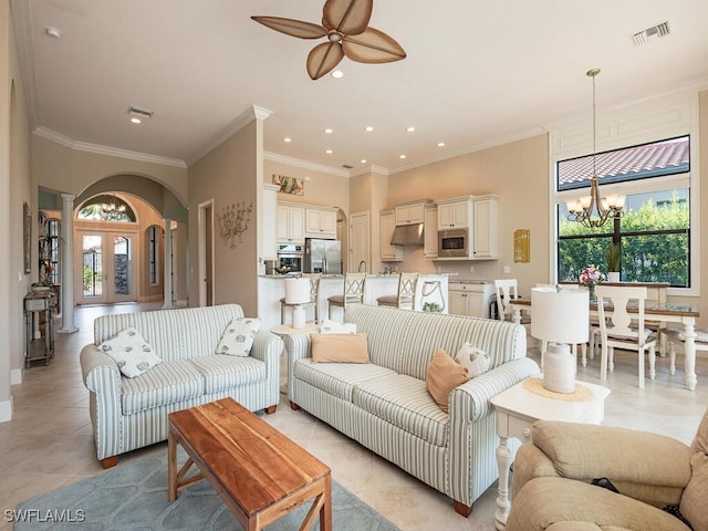 living room featuring crown molding and ceiling fan with notable chandelier