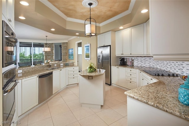 kitchen featuring light stone countertops, a tray ceiling, decorative light fixtures, and stainless steel appliances