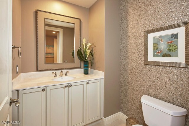 bathroom with vanity, tile patterned flooring, and toilet