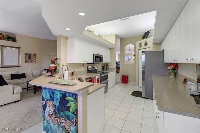 kitchen featuring white cabinets, sink, appliances with stainless steel finishes, and kitchen peninsula