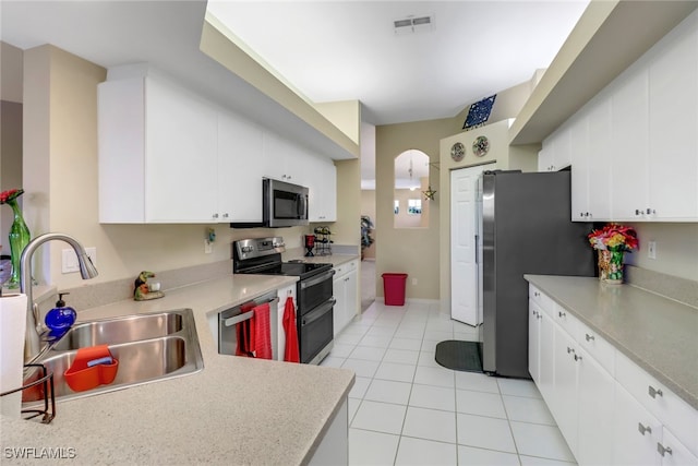 kitchen featuring appliances with stainless steel finishes, white cabinetry, sink, and light tile patterned flooring